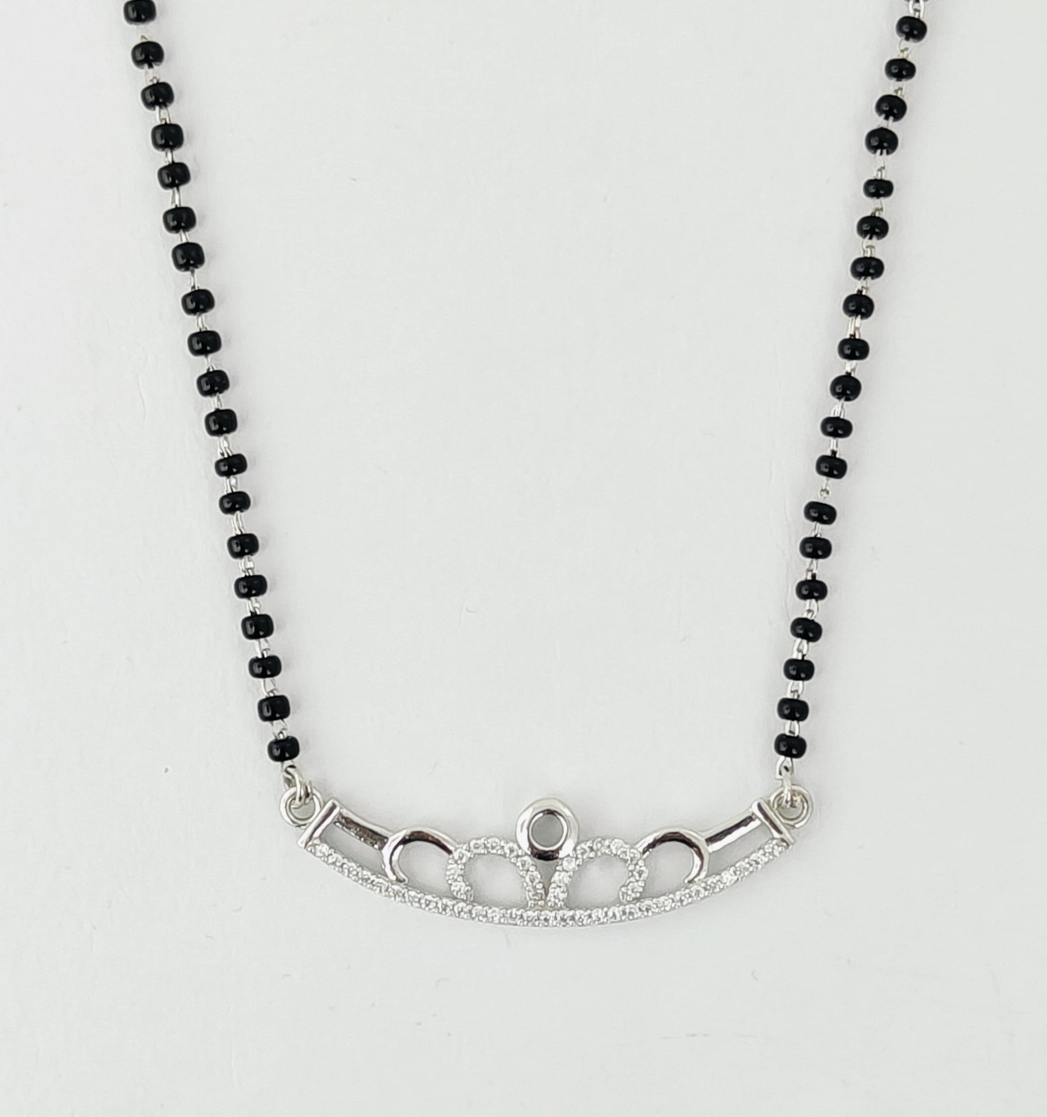 Necklace with black beads and silver clasp on a white background
